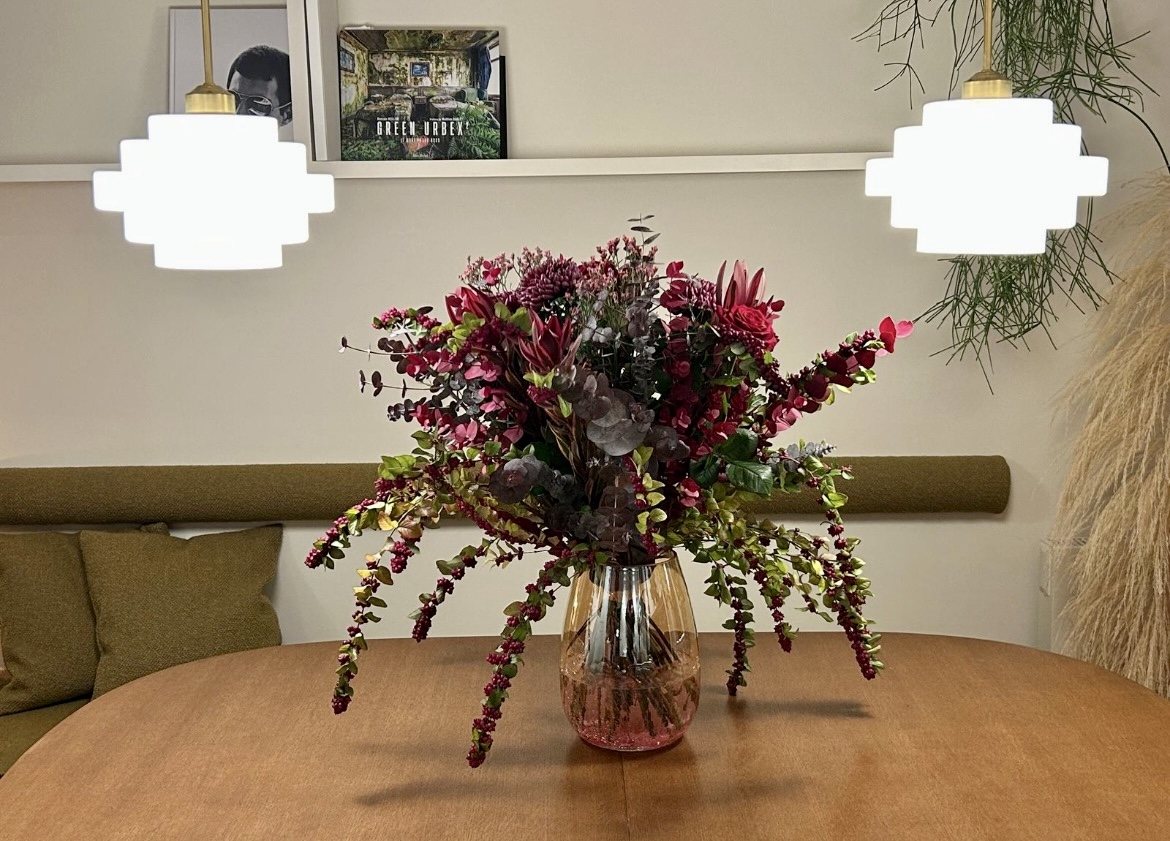 Composition de fleurs bordeaux sur une table